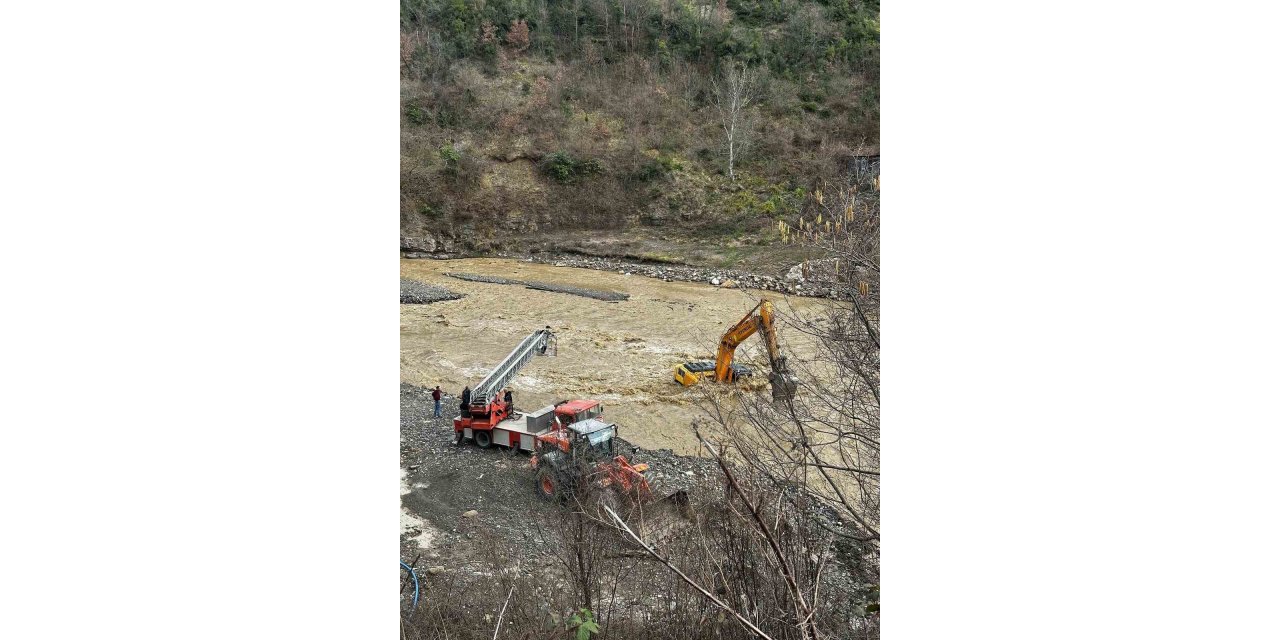 Çayın debisi yükselince iş makinesinin üzerinde mahsur kaldı